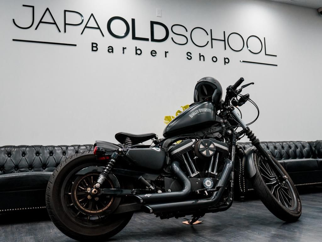 Barber chairs and lounge area with motorcycle display at JAPA OLD SCHOOL BARBERSHOP